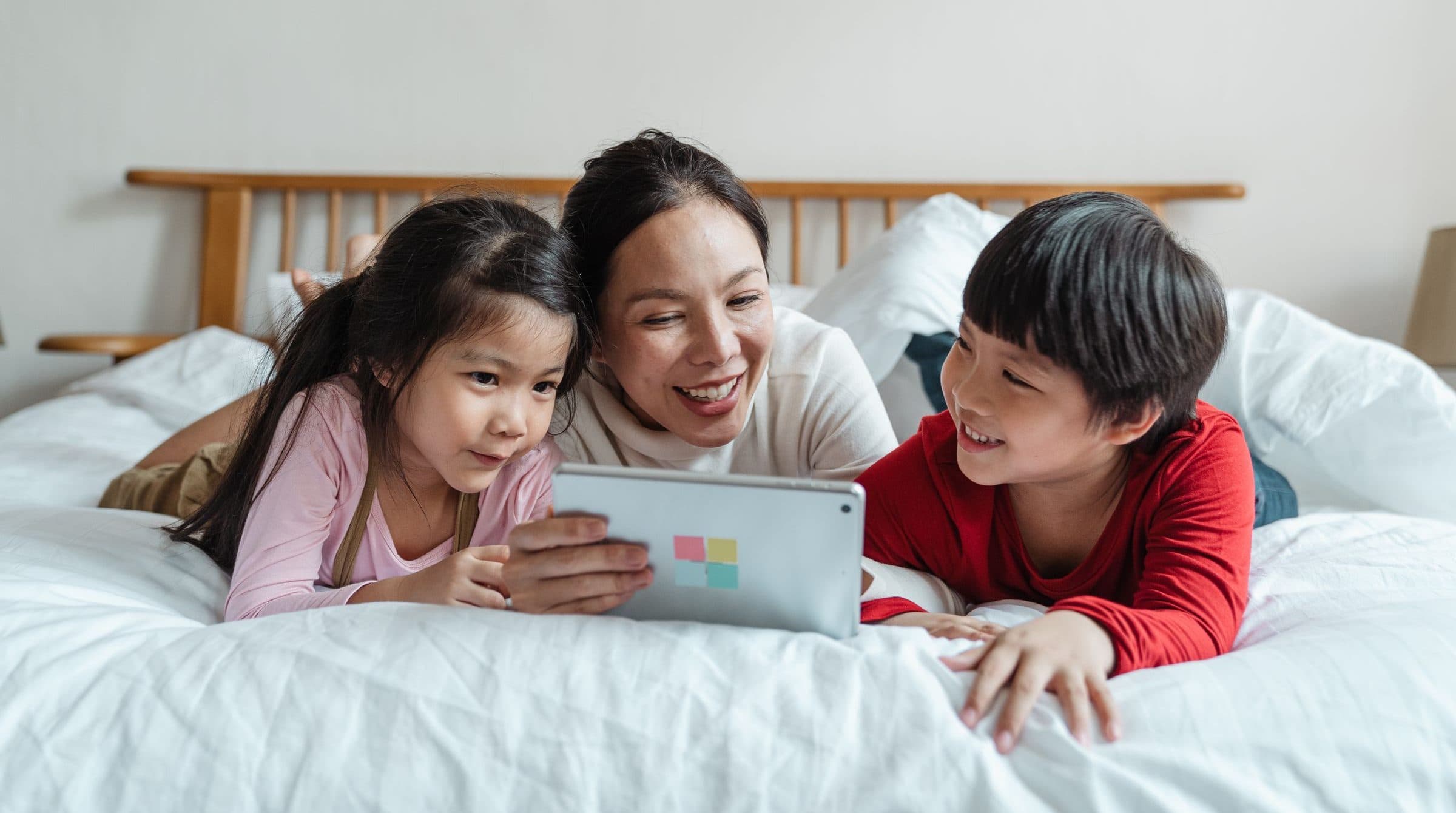 A smiling family looking at a tablet together